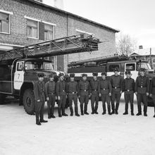 военнослужащие пожарной части около гаража с пожарными машинами | ЖКХ. 1979 г., г.Северодвинск. Фото #C474.