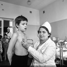 медработник слушает с помощью фонендоскопа мальчика | Медицина. 1979 г., г.Северодвинск. Фото #C728.
