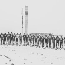 Группа лыжников с нагрудными номерами около въездного знака | Спорт. 1979 г., г.Северодвинск. Фото #C885.