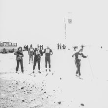 лыжники с нагрудными номерами около въездного знака | Спорт. 1979 г., г.Северодвинск. Фото #C886.