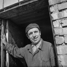 портрет строителя на фоне оконного проема и кирпичной кладки | Строительство. 1979 г., г.Северодвинск. Фото #C916.