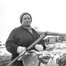 работница деревообрабатывающего предприятия около бревен | Предприятия. 1979 г., г.Северодвинск. Фото #C1049.