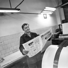 Печатник городской типографии со свежим номером газеты "Северный рабочий" | Предприятия. 1987 г., г.Северодвинск. Фото #C11781.